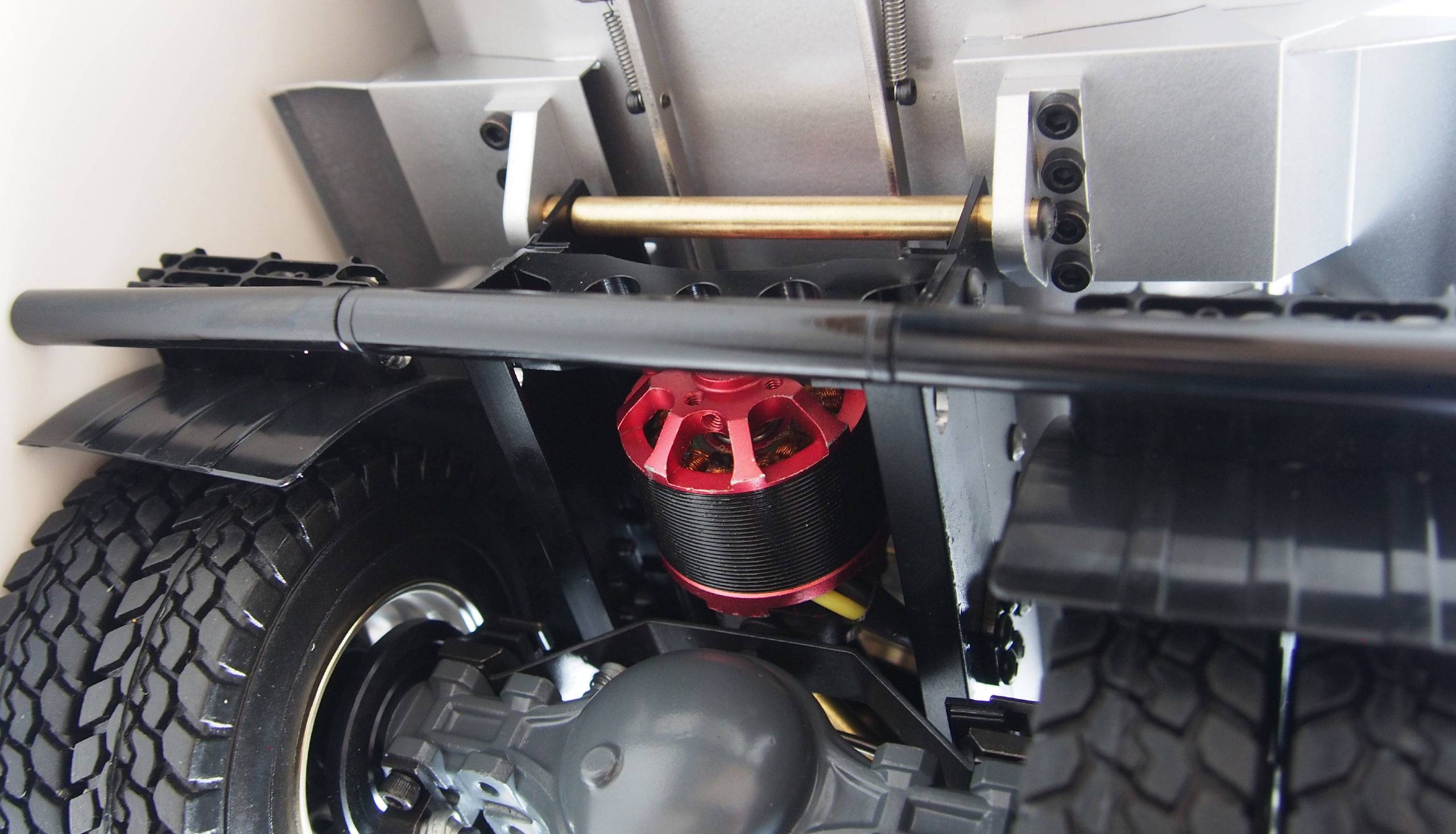 Underside of a model car with a detailed close-up view of the suspension and electric motor.