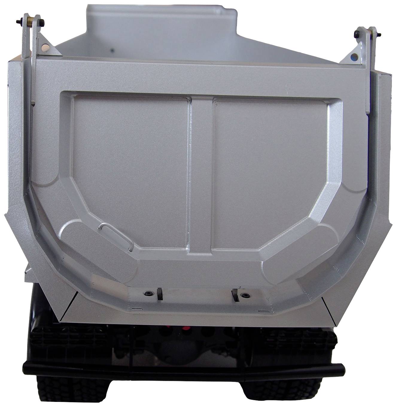 A silver tipper lorry from behind, with raised load bed and visible tyres, demonstrates robust construction.