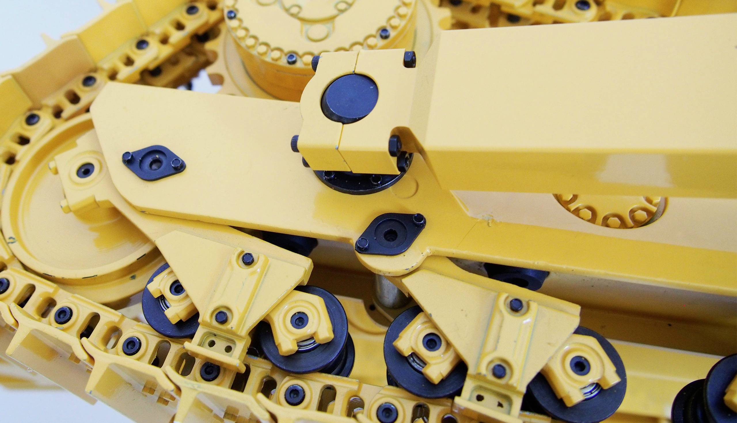 Close-up of a yellow construction crane with chains and gears. Clearly visible mechanical details showing its mode of operation.