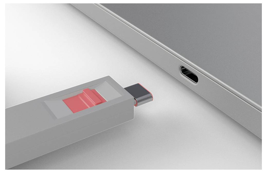 Close-up of a USB flash drive with a red slider, positioned to plug into a laptop’s USB port.