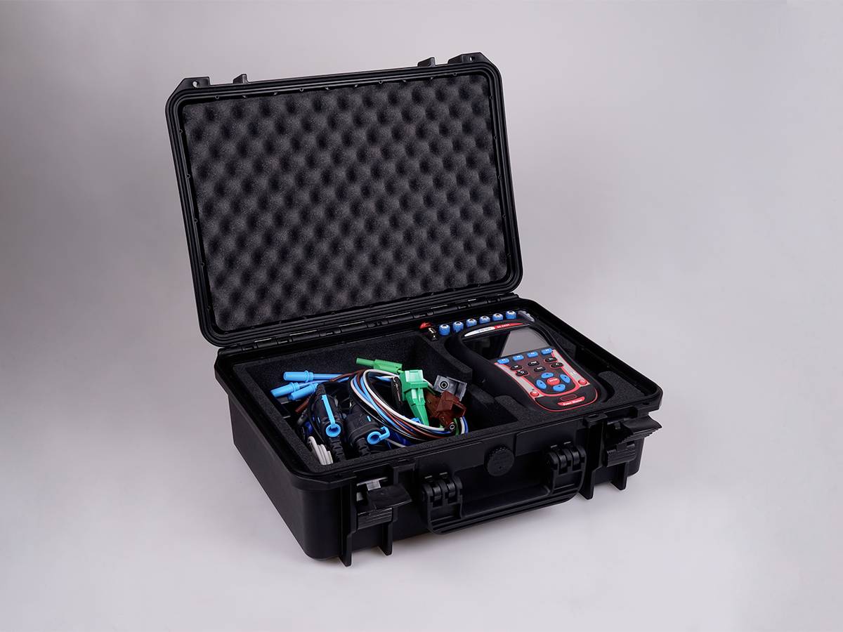 An open toolbox with an electronic testing device and cable accessories.