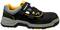 A black work shoe with a grey sole, yellow inner lining and a hook and loop fastener, suitable for workplace safety.