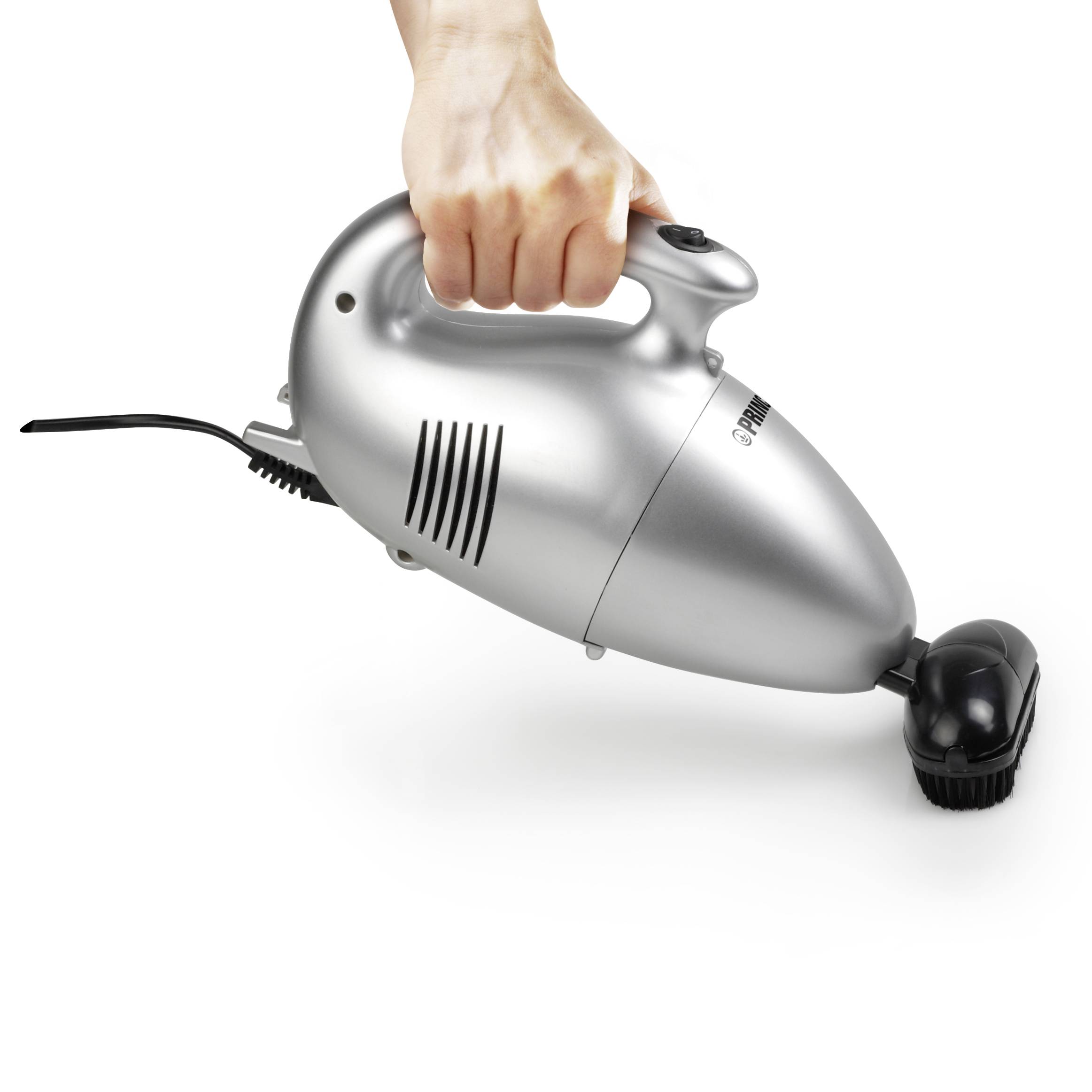 A hand is holding a silver handheld vacuum cleaner that stands upright. The vacuum cleaner has a power cord and a black brush.