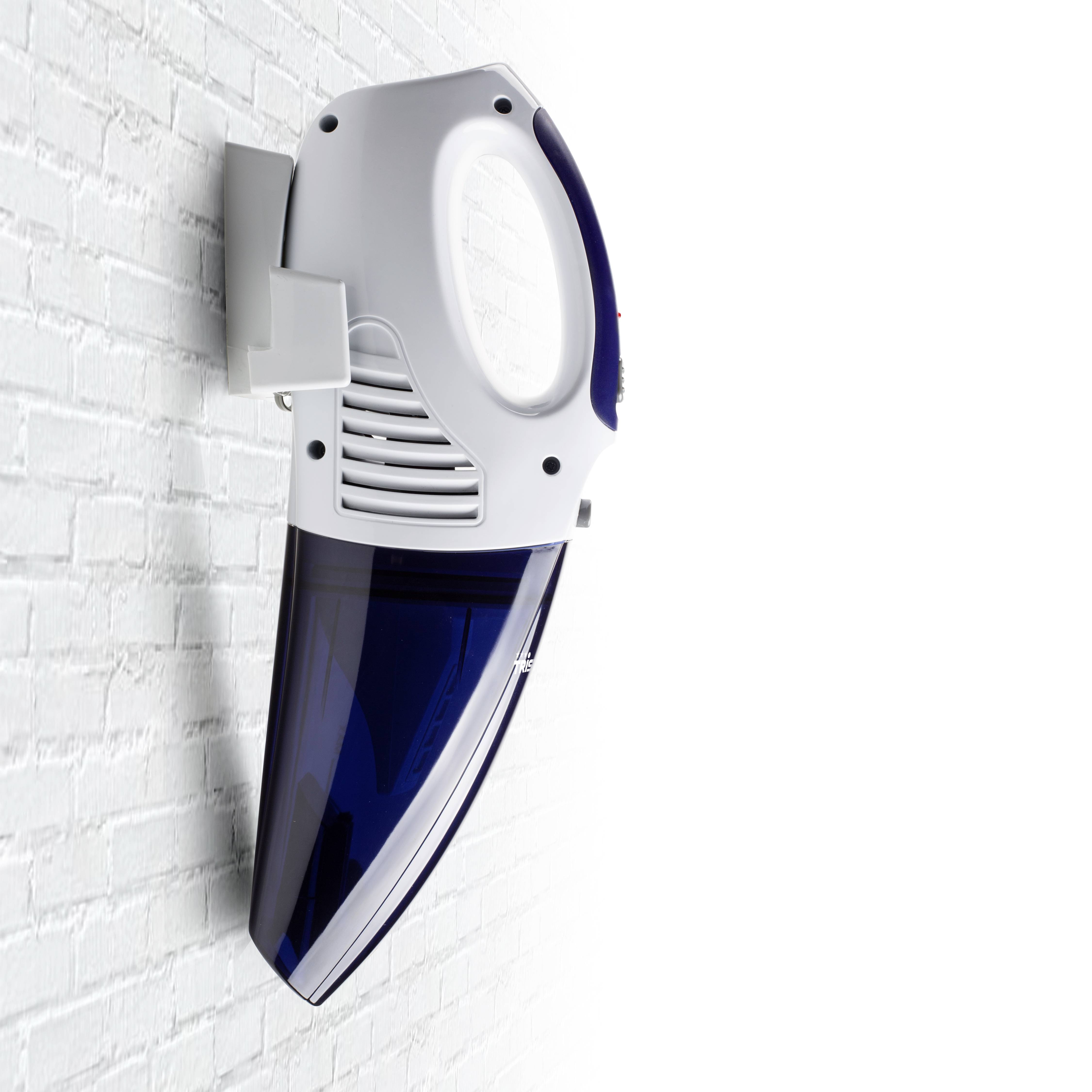 A handy, cordless vacuum cleaner in blue and white is mounted on a white brick wall.