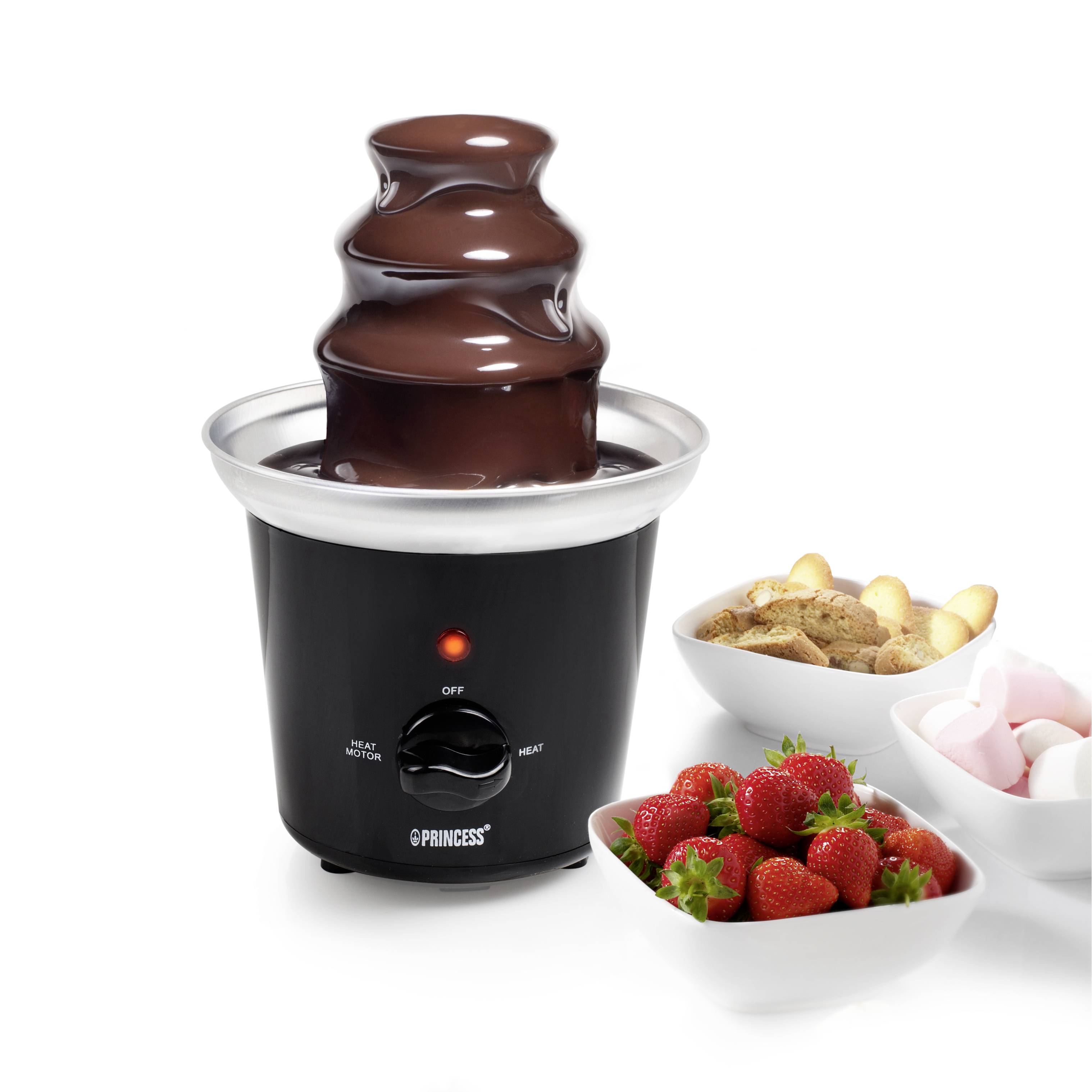 A chocolate fountain with flowing chocolate stands on a table. Beside it are strawberries, marshmallows and biscuits as accompaniments.