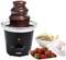 A chocolate fountain, surrounded by bowls of strawberries, biscuits, and marshmallows, invites you to dip in.
