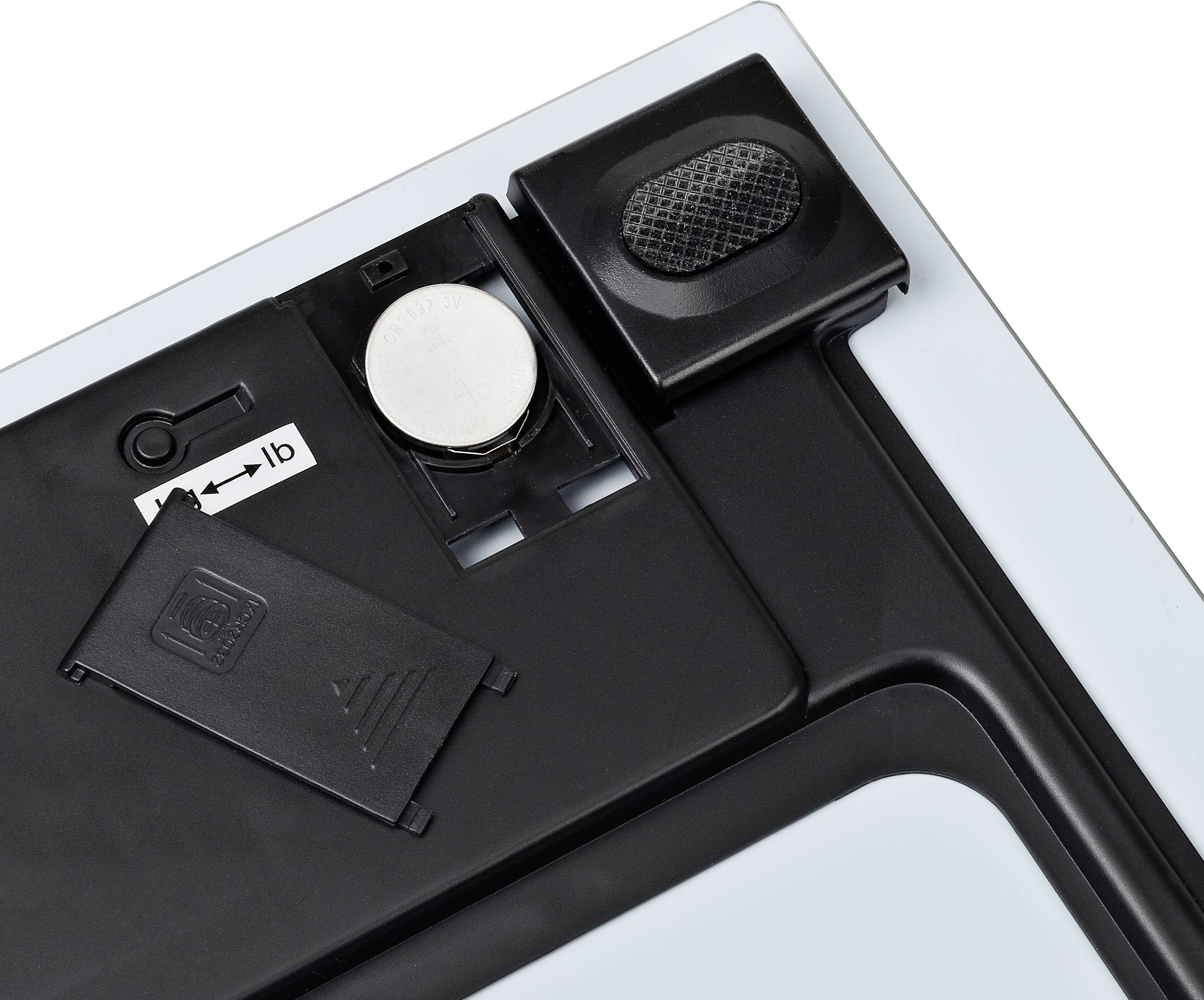 Battery compartment of an electronic device with an open cover. Battery is visible, arrow indicates the installation direction.