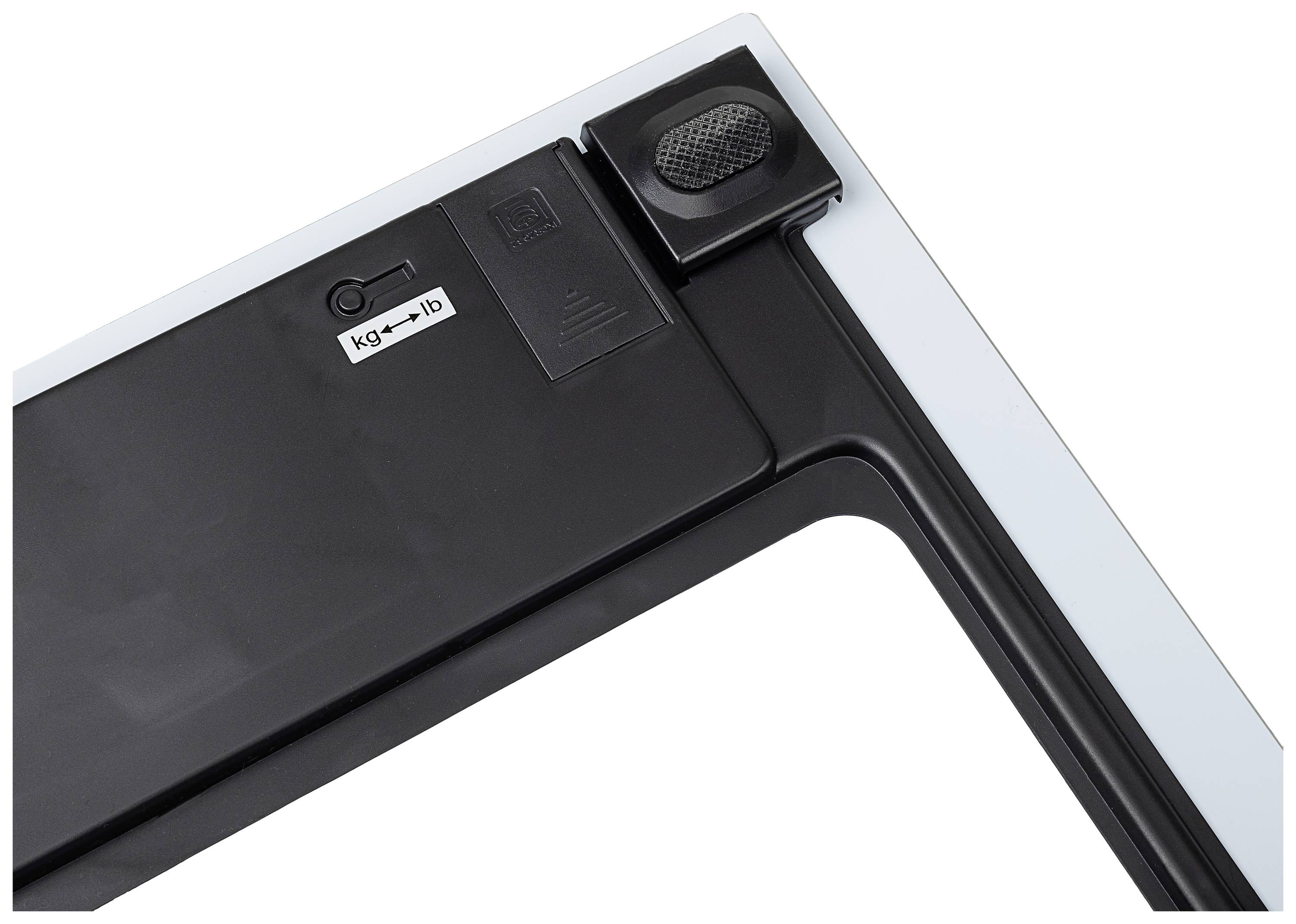 Close-up of a black glass weighing scale with a rotary switch to toggle between kilograms and pounds.