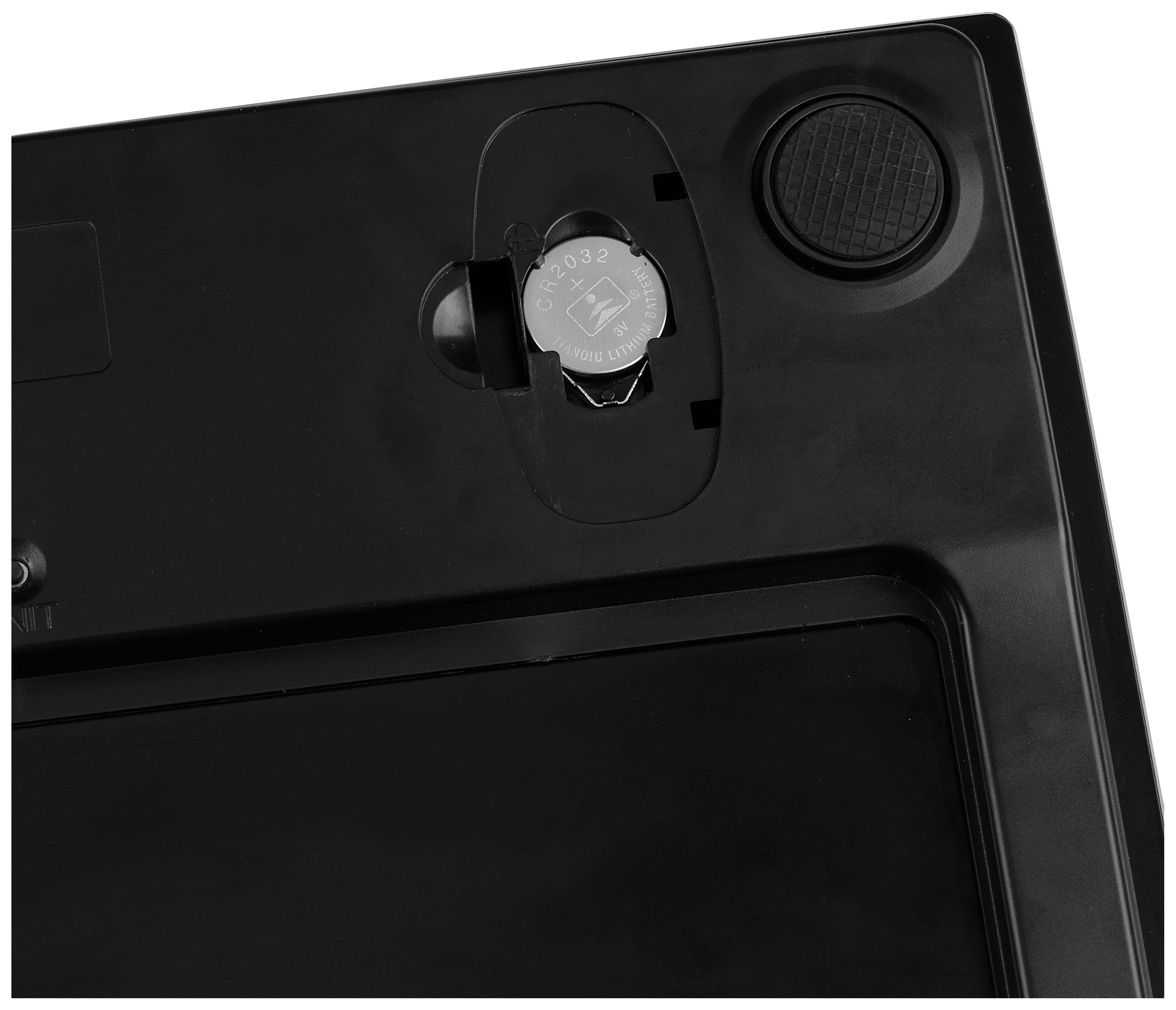 Rear view of an electronic device with an open battery compartment showing a single button cell battery (CR2032).