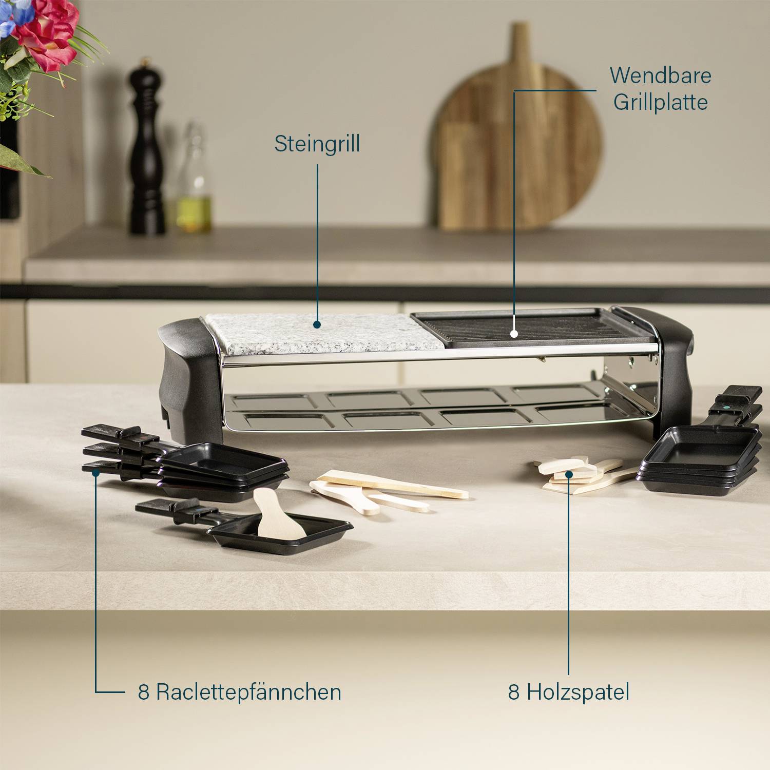 A stone grill with a reversible griddle plate is placed on a table. Alongside 8 raclette dishes and 8 wooden spatulas. Background: a kitchen.