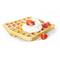 A golden-brown waffle dusted with icing sugar, garnished with a dollop of cream and fresh strawberry pieces.