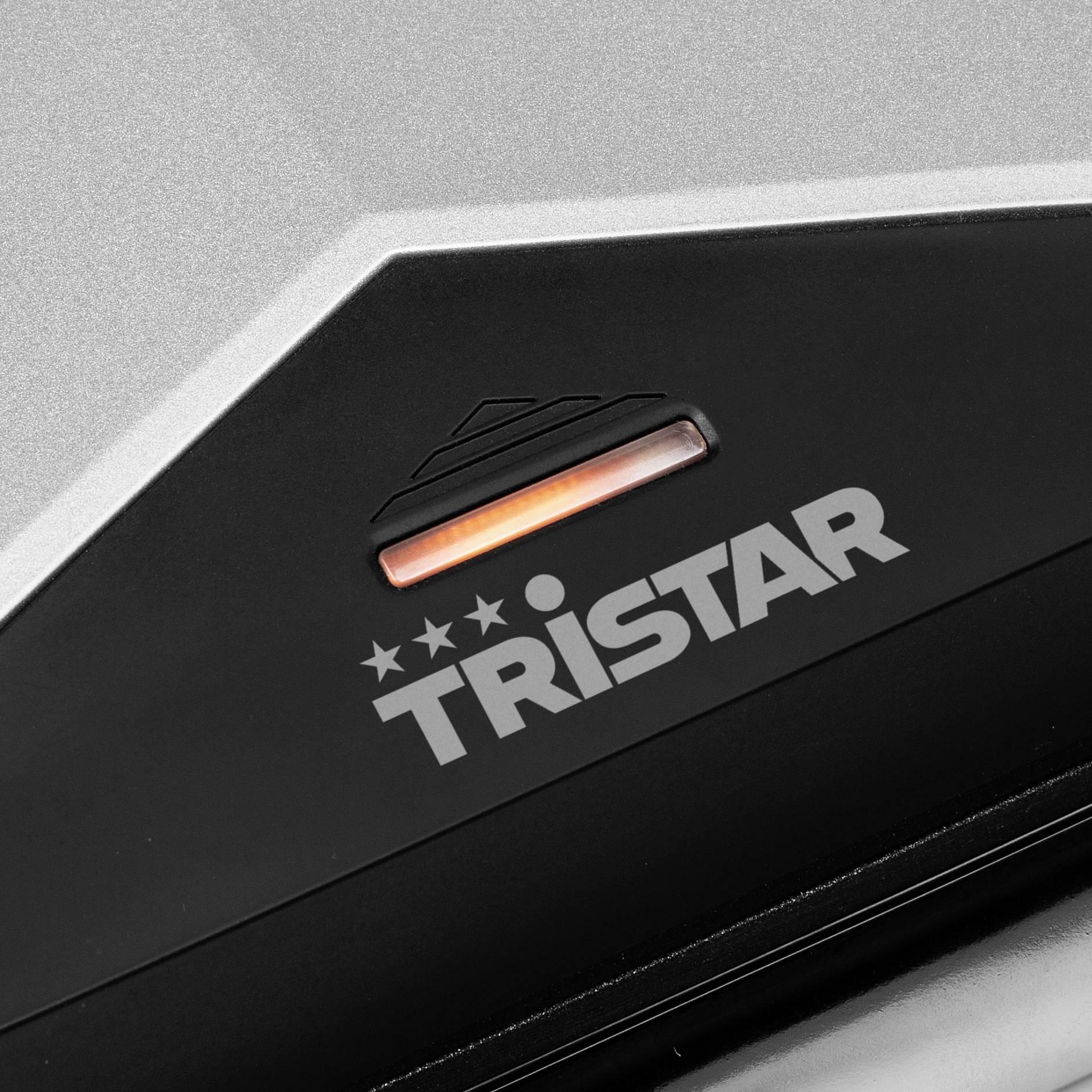 A black and silver device, presumably a household appliance, with the brand name 'Tristar' and a glowing red indicator light.