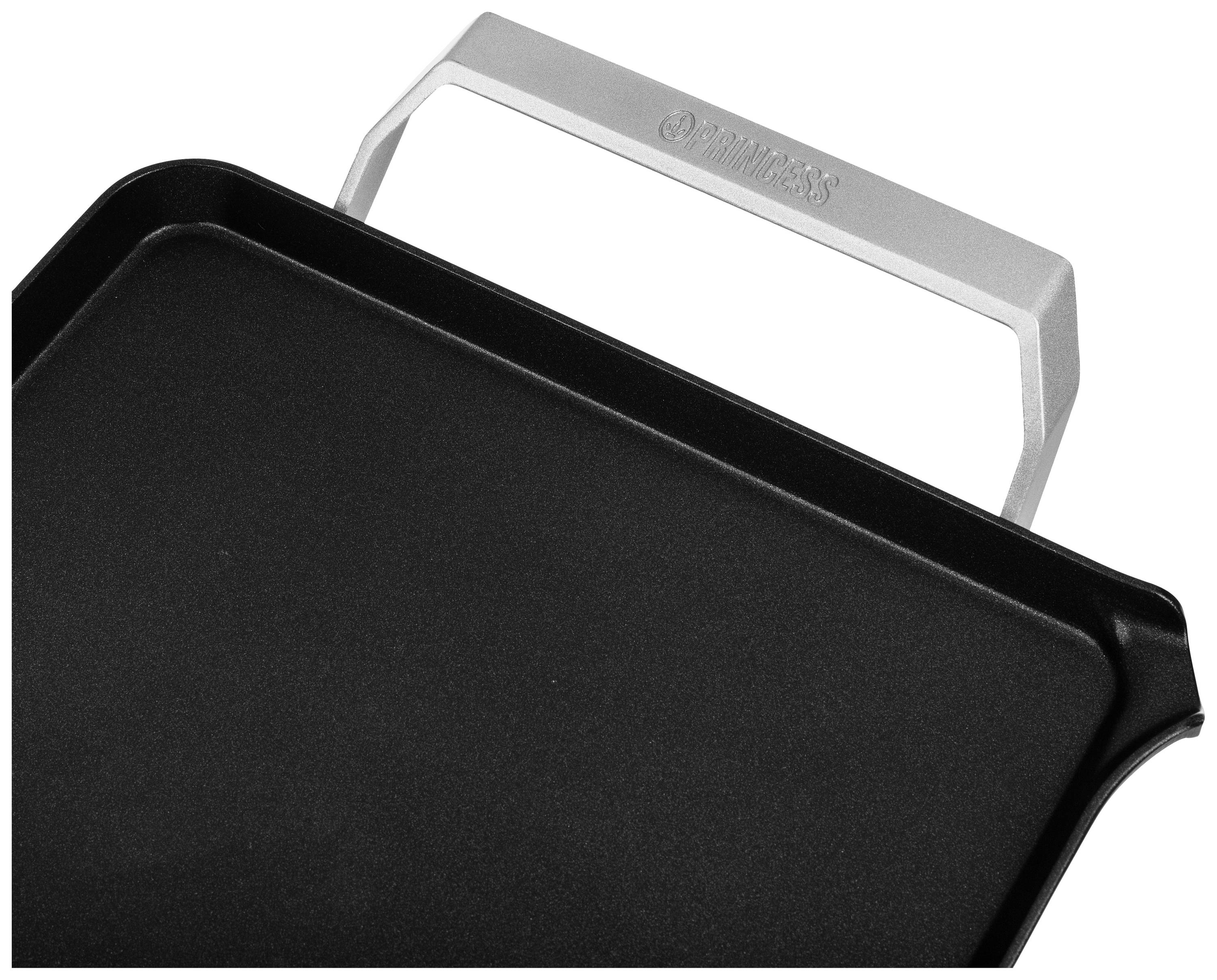 Black griddle plate with silver handle, slightly angled. Ideal for grilling a variety of foods.