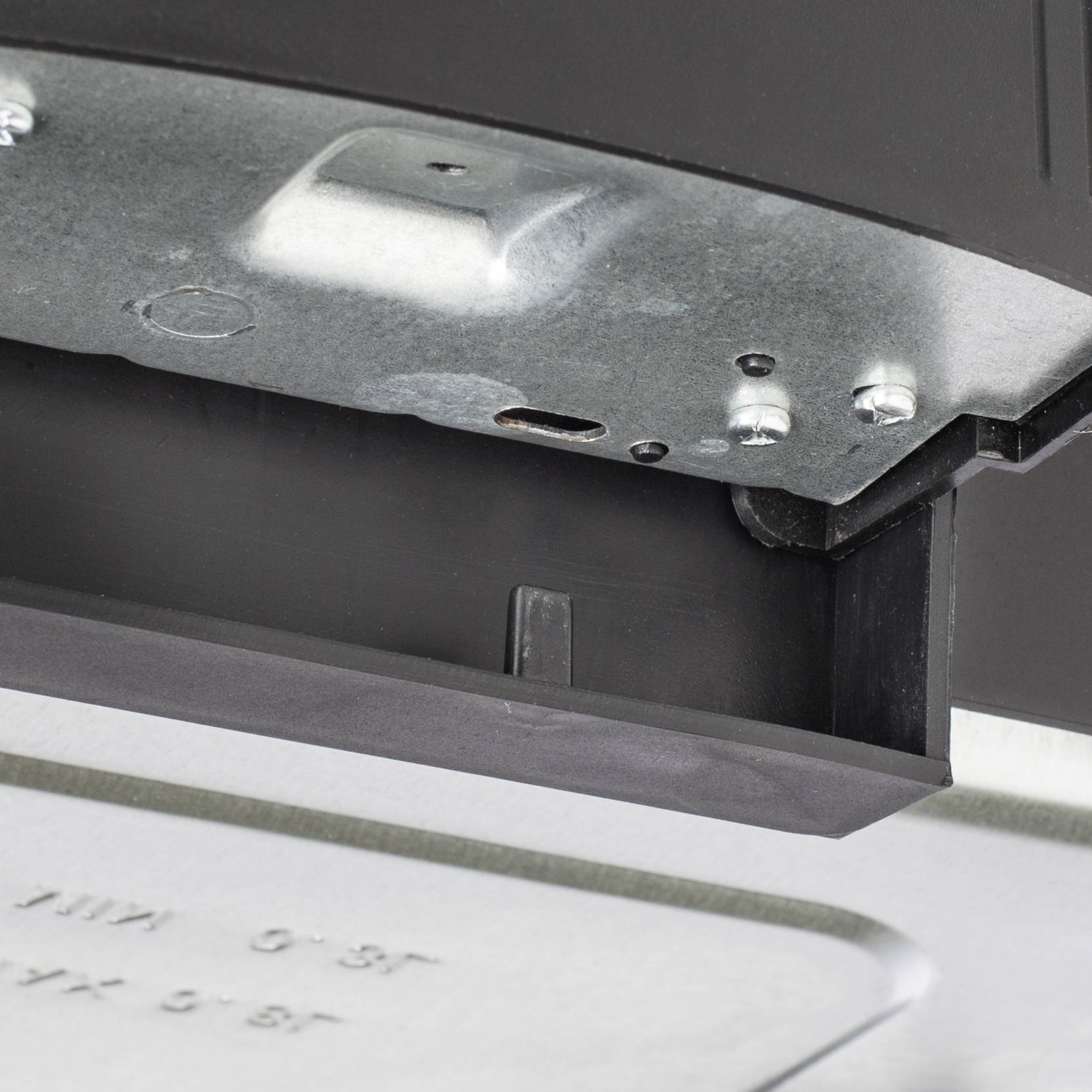 Metal part with screws and edges in close-up. Detailed shot of a potentially technical or mechanical object.