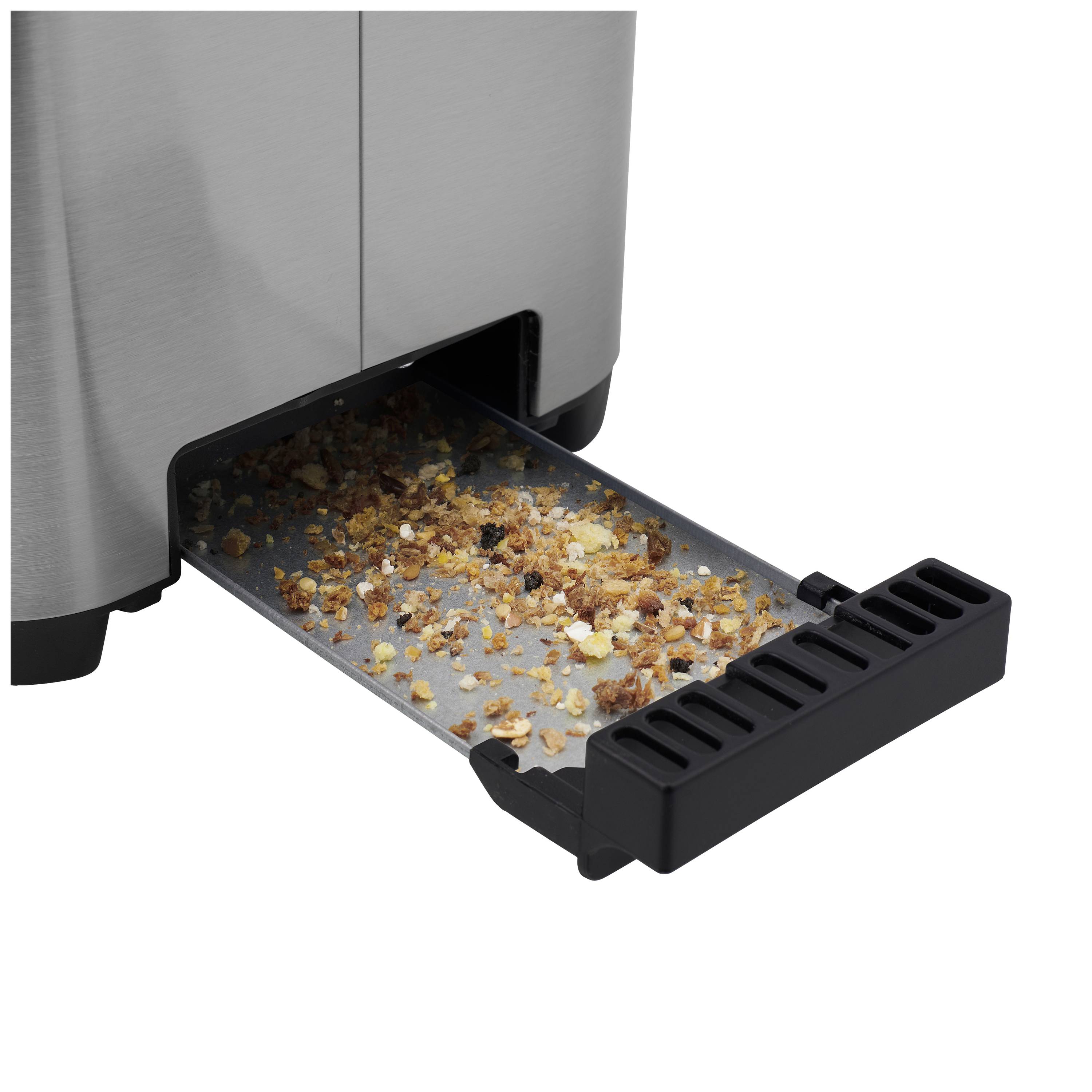 Crumb tray of a toaster, partially pulled out and filled with crumbs, shows the amount of bread remnants that have been collected.