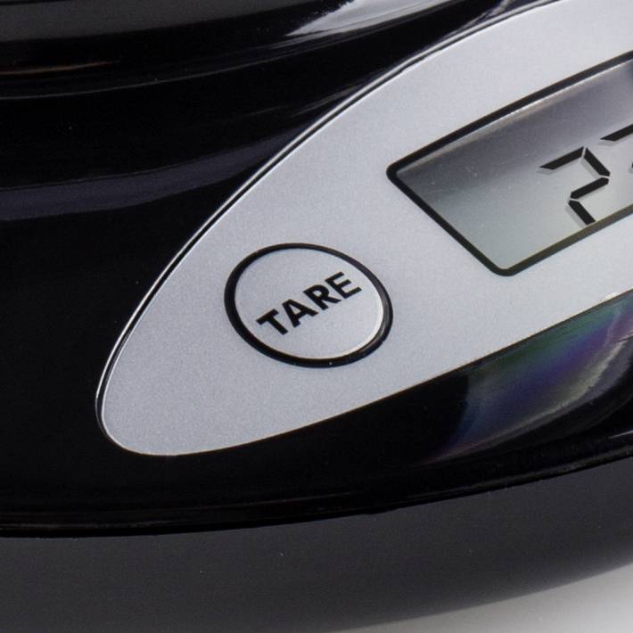 Digital kitchen scales in close-up showing a weight of 27 grams. Keypad with 'TARE' button visible.