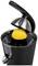 Electric citrus juicer with a black casing pressing half an orange. Focus on the juicer with a stainless steel cap.