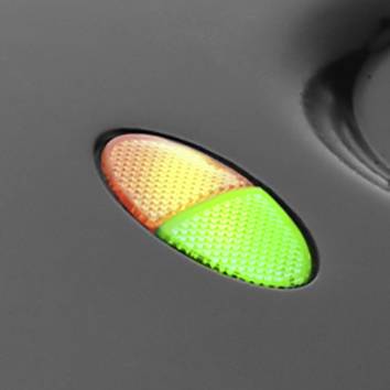 A close-up image of two adjacent warning lights: one orange and one green, on a grey background.