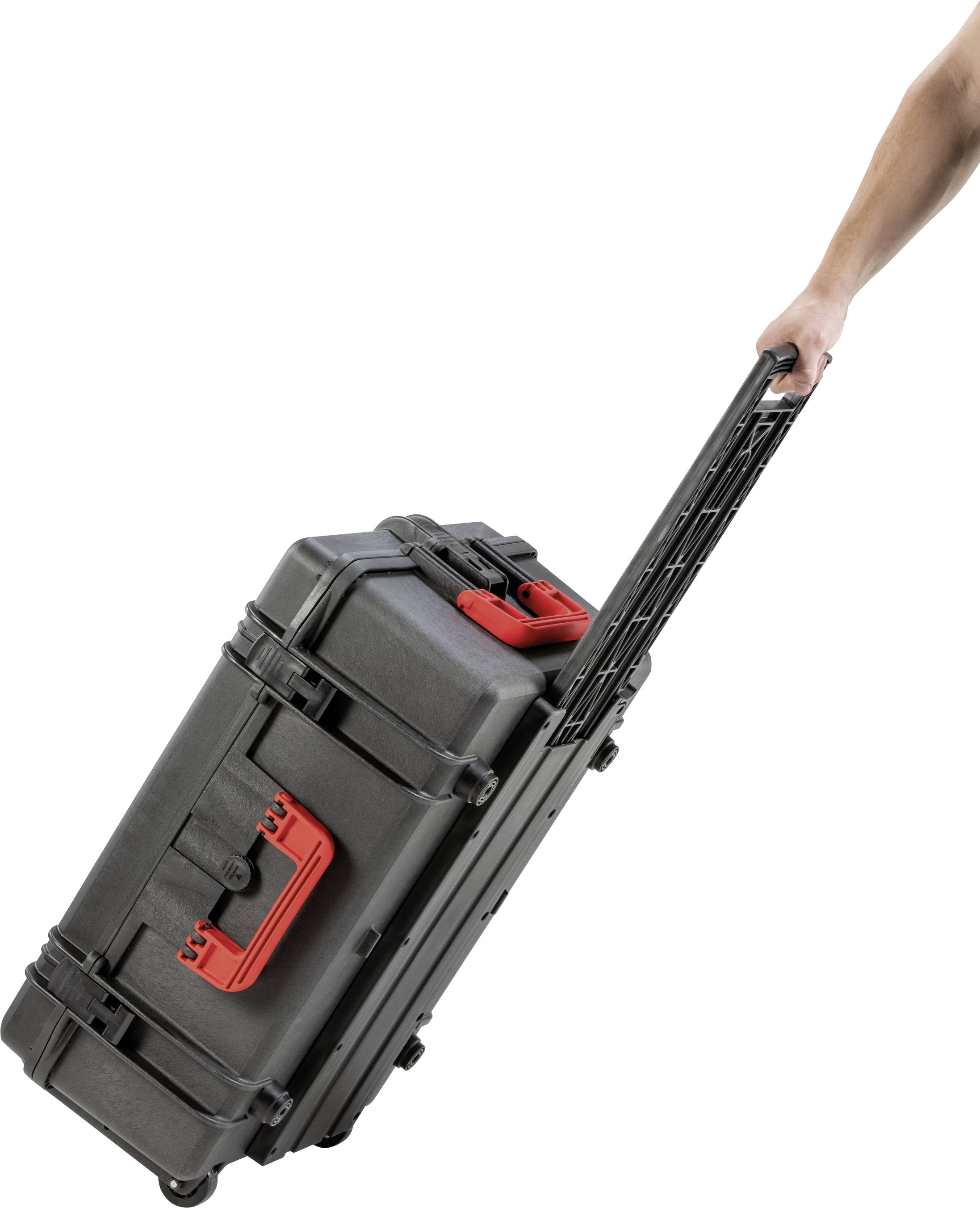 A person is pulling a black, sturdy suitcase with red handles behind them by its extendable handle.