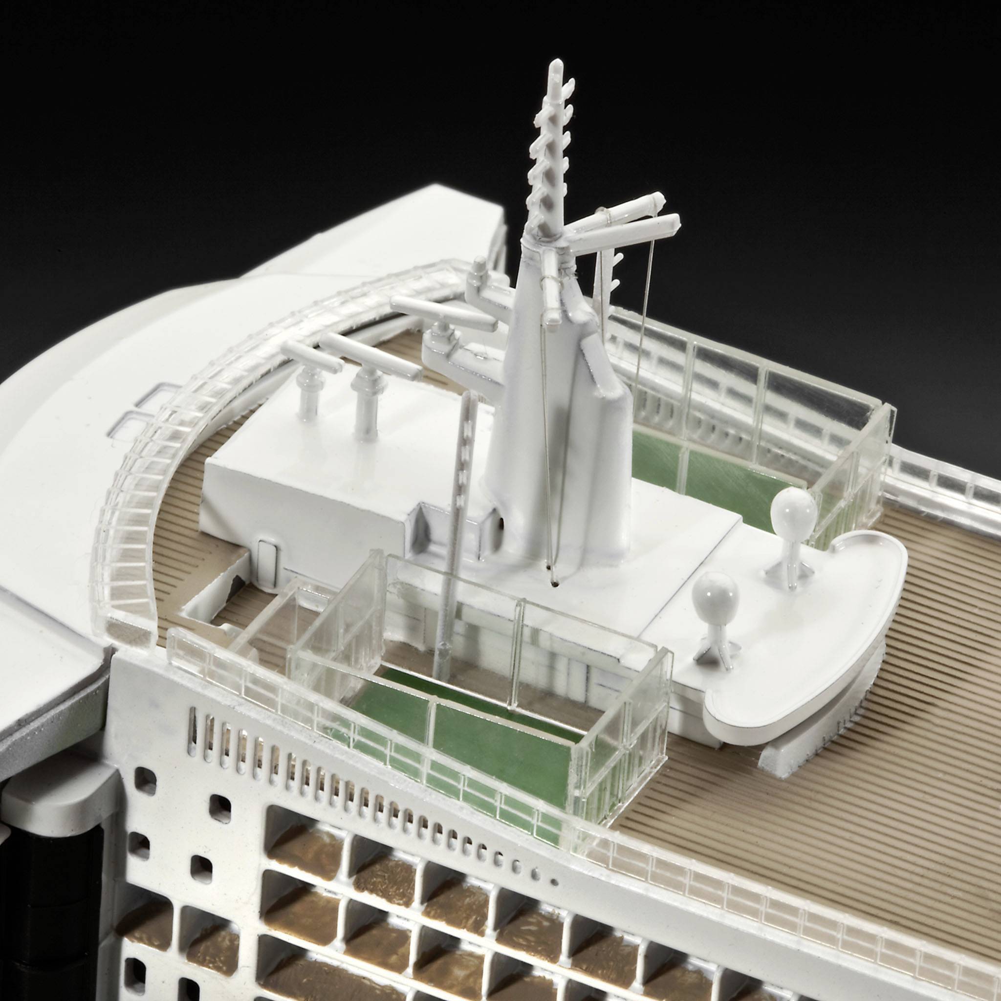 Upper section of a cruise ship model with details such as aerials, funnel and deck areas, on a black background.