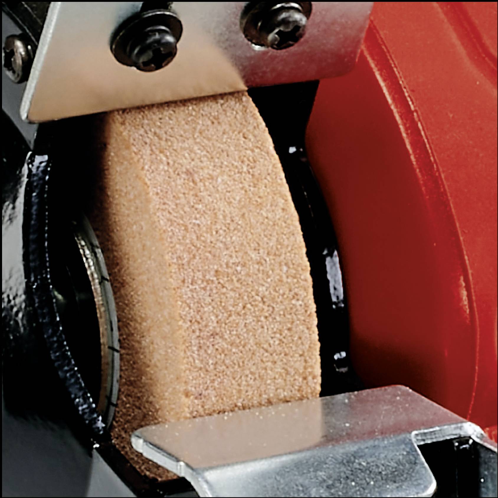 A grinding wheel is driven by an electric motor to shape or smooth metals or other materials.