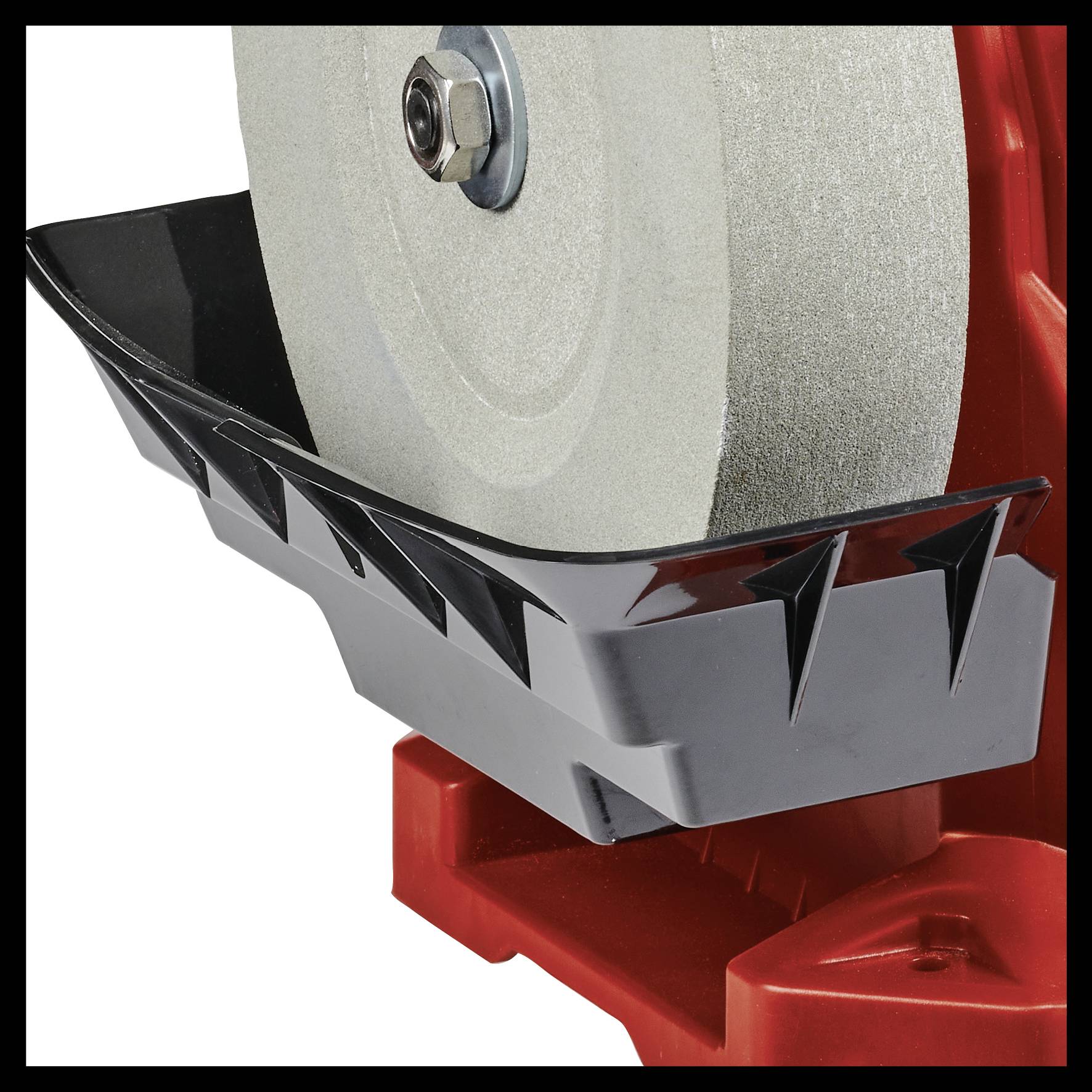 Close-up of a grinding wheel on a machine. The grinding wheel is fitted with a protective cover to ensure safety.