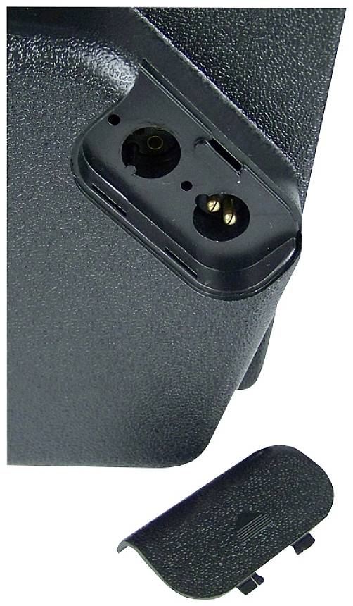 'Detail of an opened battery compartment of a black electronic device, with two metal contacts. Cover lying separately underneath.'