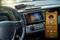 A car dashboard with a touchscreen navigation system, connected to a smartphone playing music from 'Old Jack Swing'.