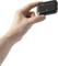 A hand is holding a small, rectangular, black electronic device with a blue symbol and brand logo on it.