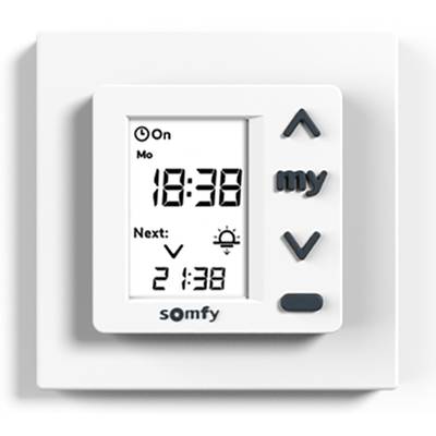 Electronic wall switch with display showing 'Mon 18:38'. Buttons for settings and timer. Brand 'Somfy'.