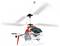 A model helicopter with a red and white design and a shark mouth decal is flying with rotating rotor blades.