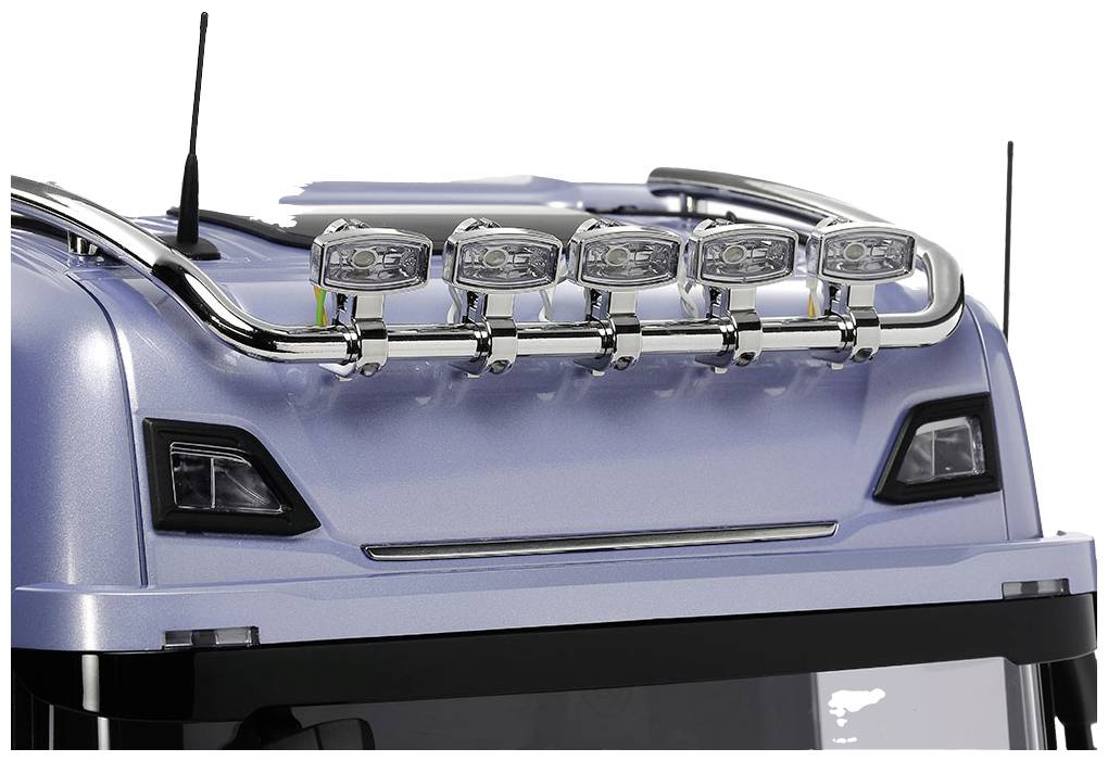 Upper front section of a blue lorry with five silver headlamps mounted on the roof, installed for additional illumination.