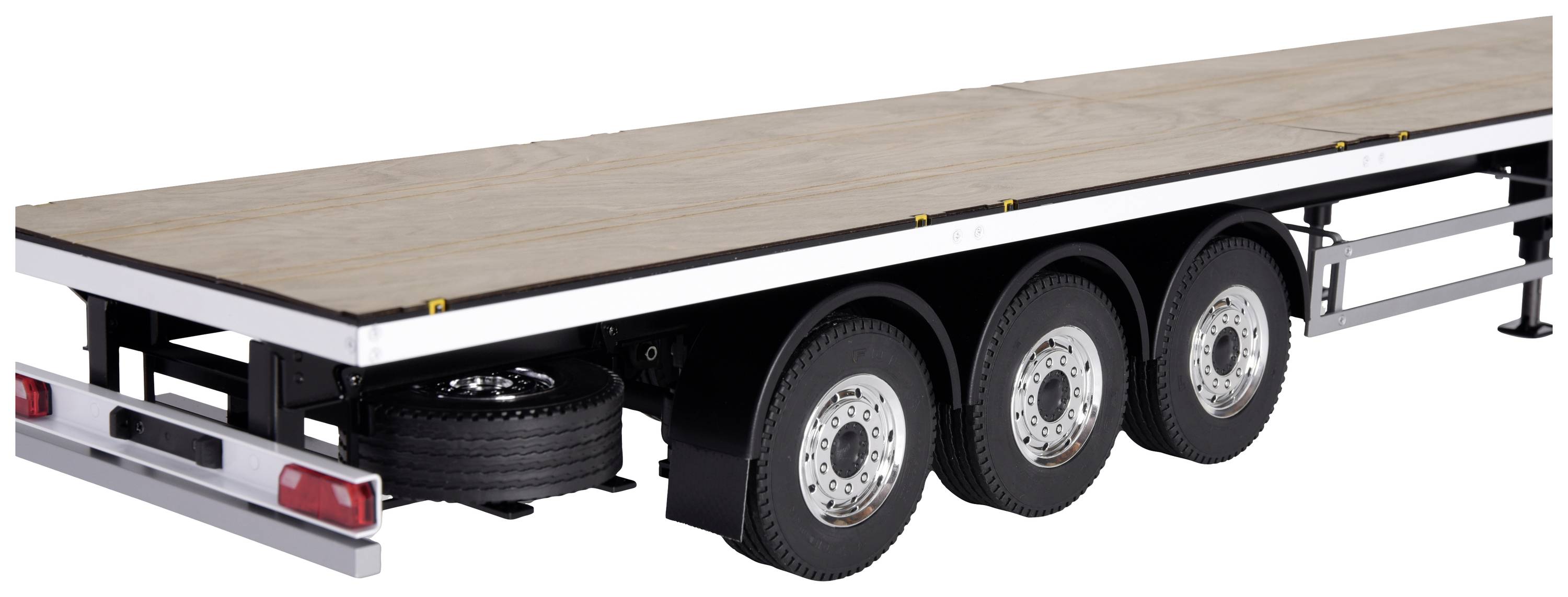 'An empty three-axle trailer without bodywork, with a flat platform and spare tyres, suitable for the transportation of goods.'