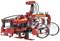 Toy model of a fire-fighting robot made from red building blocks with a distinctive 'Firefighter' inscription. The robot has articulated arms and two large glass bottles that appear to function as water tanks.