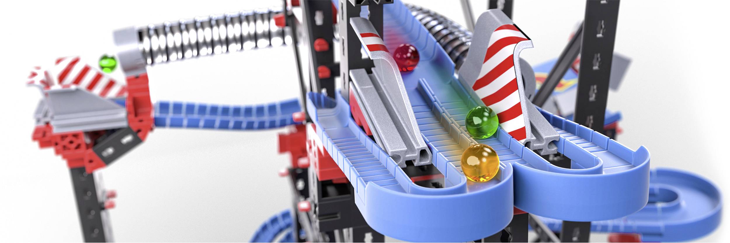 Marble run construction with colourful marbles moving along blue tracks. Spiral ramps and lifting mechanisms complement the route.