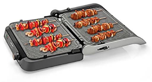 An opened electric grill with multiple skewers featuring red and orange vegetables and meat.