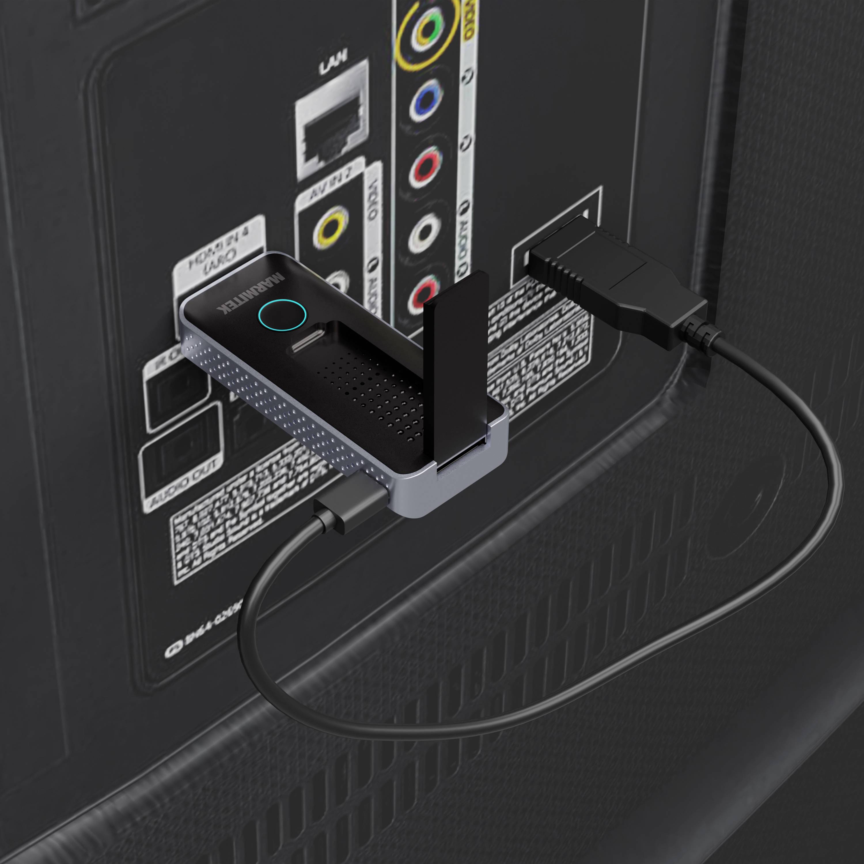 An HDMI dongle is connected to the back of a television. Beside it are additional ports, including audio and video inputs.