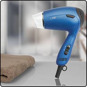 Blue travel hairdryer on a table, next to a brown towel.