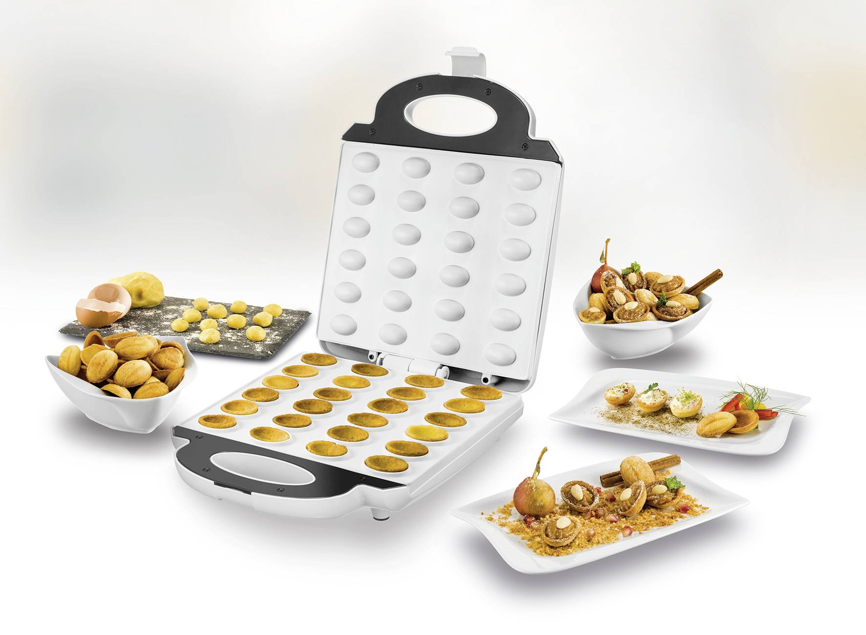 A waffle iron with an open lid displays baked round waffles. Beside it are plates with various sweet and savoury dishes.
