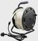 A black cable reel with cable wound around it, handle at the top for carrying, with a socket and plug at the cable ends.