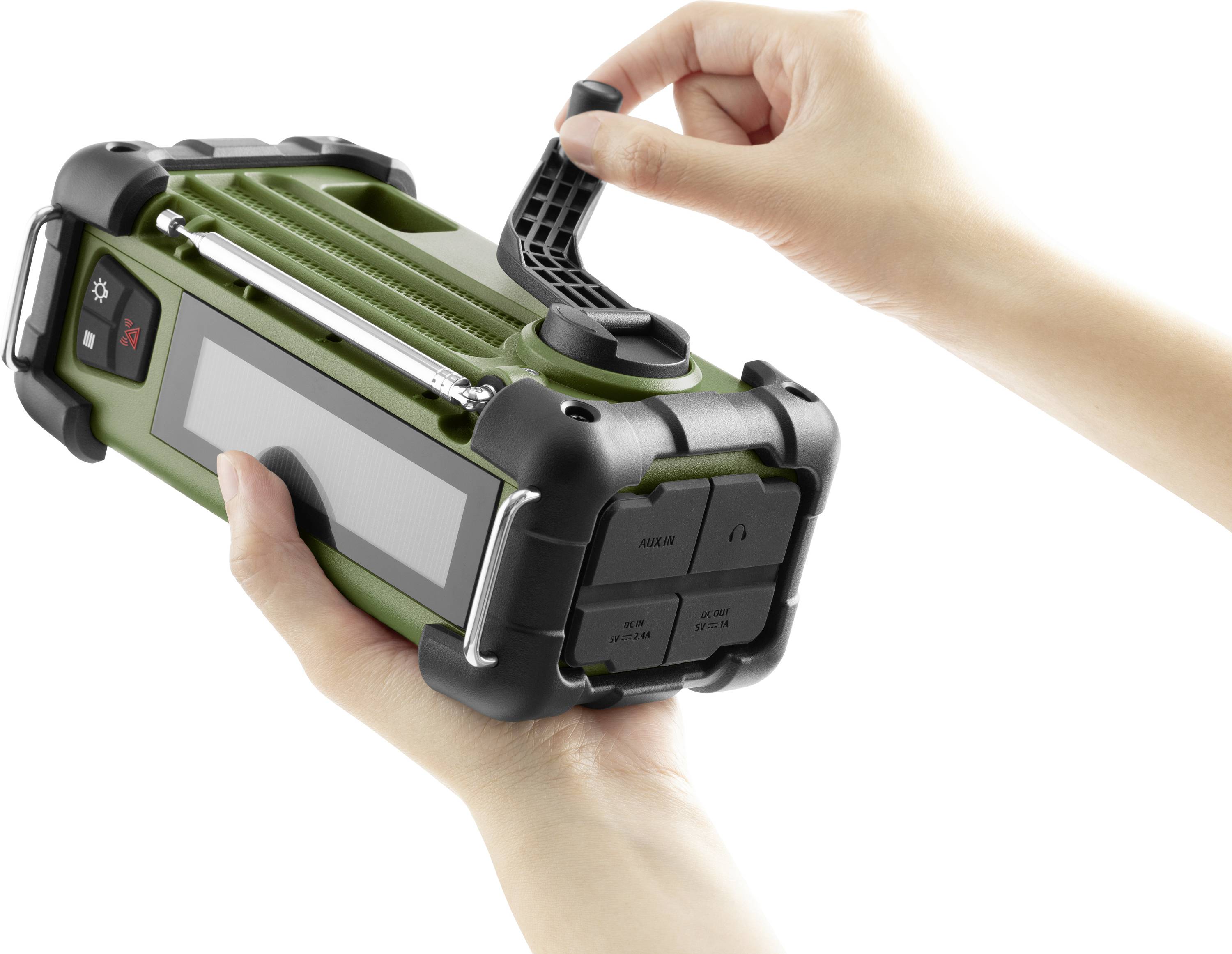 A person is holding a green portable radio in their hand. One hand is turning the crank of the device, likely to charge it.