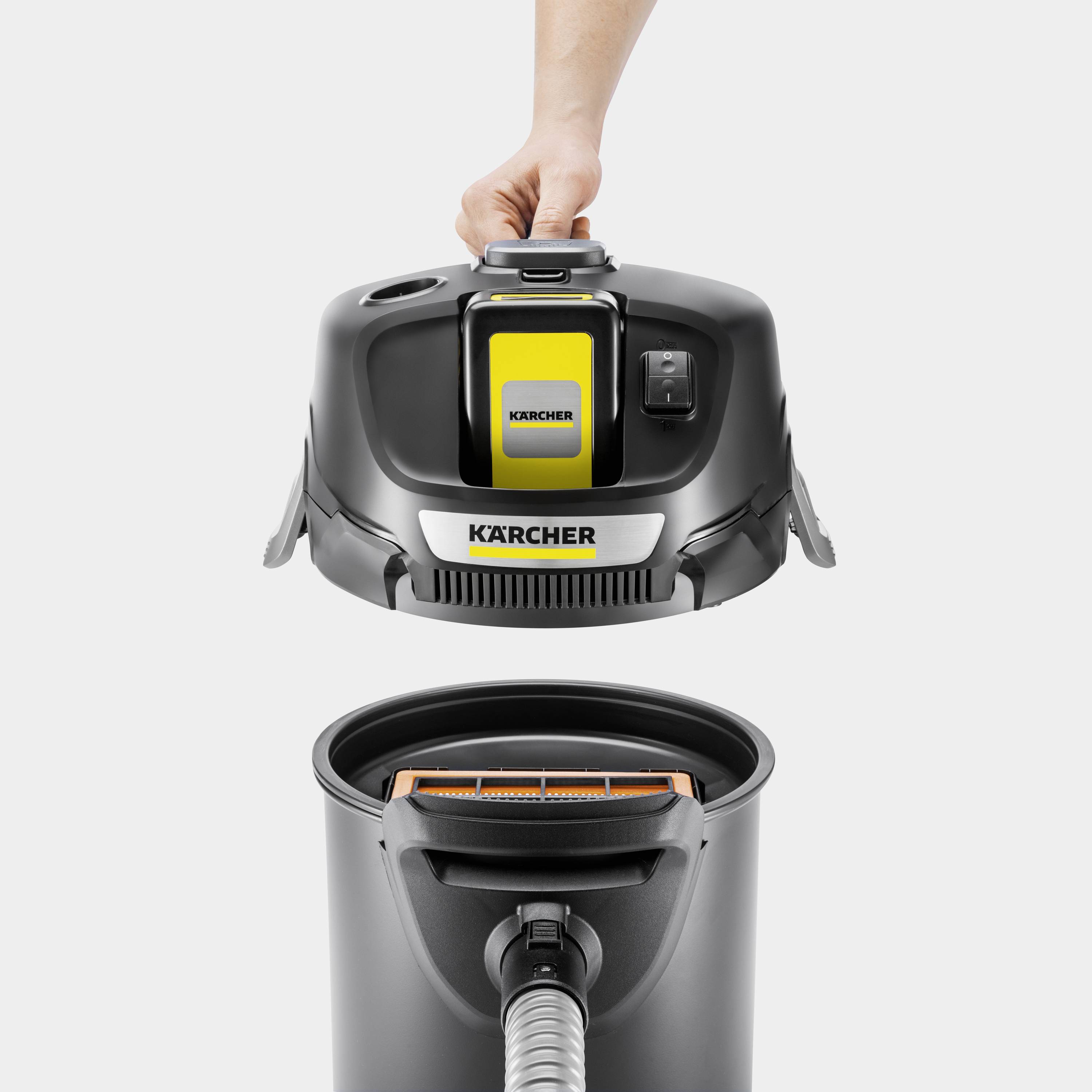 A person lifts the lid of a Kärcher vacuum cleaner. The focus is on the straightforward operation of the appliance.