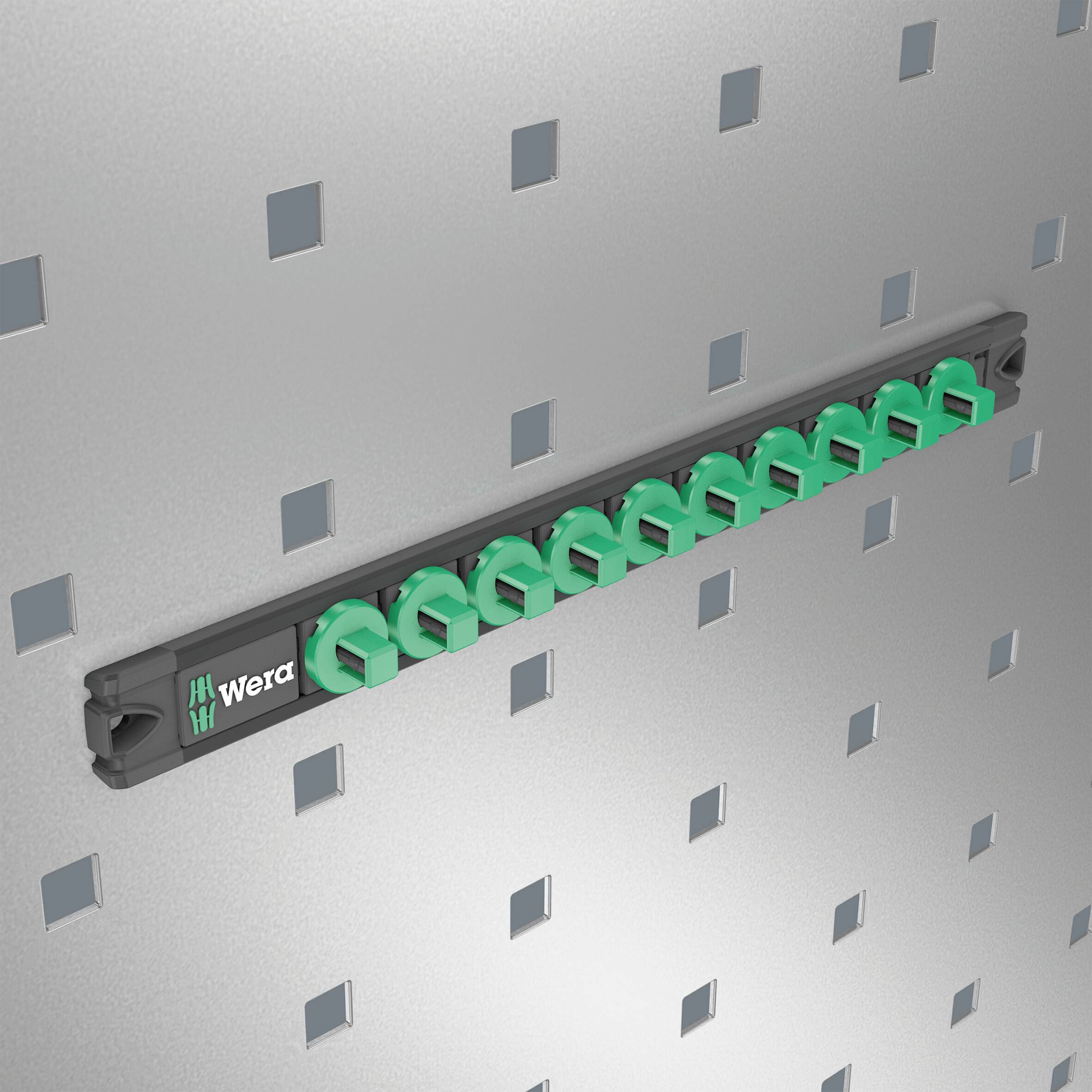 Ten-part holder with green bit magazines by Wera attached to a perforated board. Ideal for organised storage of tools.