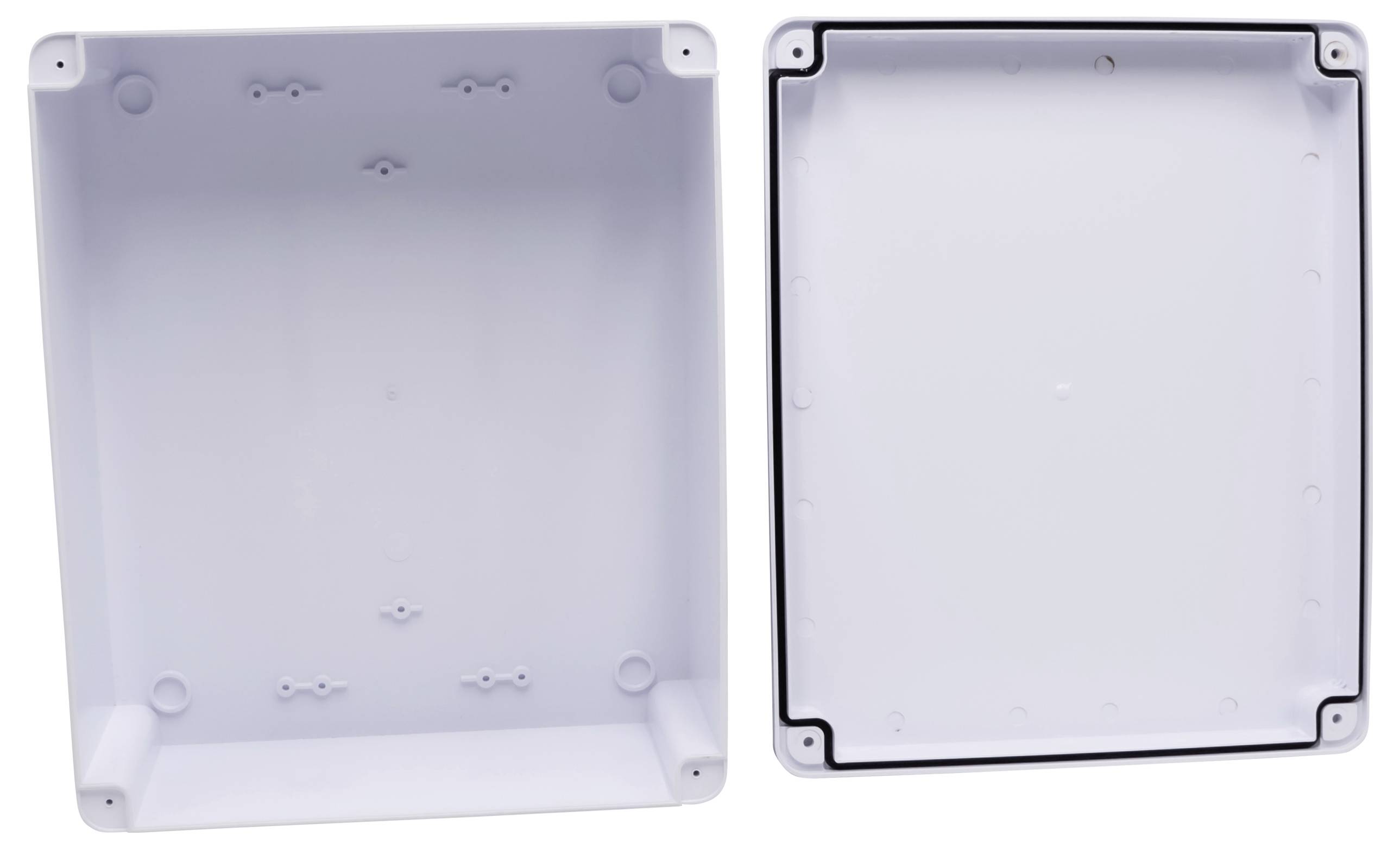 Two white rectangular plastic enclosures side by side. On the left, the enclosure with wall-mounting features, on the right the corresponding cover.