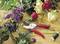 Bouquet of roses, lisianthus and ferns on a table. Beside it lies a red garden secateurs and green florist's wire.