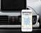 A smartphone displays a map application with a route in Northern Germany. It is placed in a car, with air vents in the background.