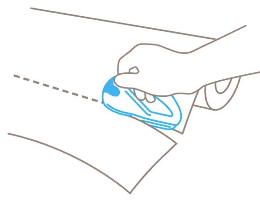 A hand is using a device to cut along a dotted line. The paper is being cut cleanly.