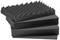 Four pieces of black acoustic foam with a wavy surface texture, stacked. They absorb sound and reduce echo.