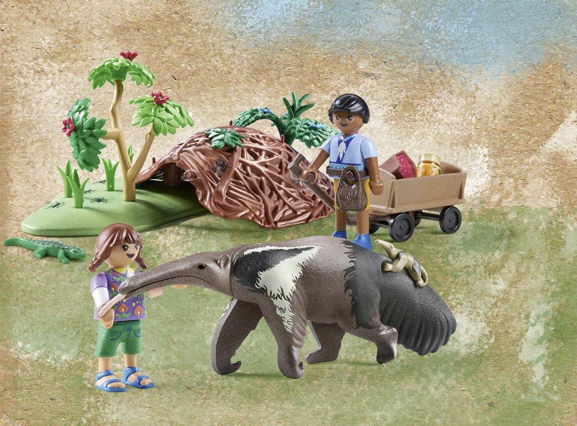 Toy figure scene: Child with anteater, tree, toy wagon and hut. Another character is pushing the wagon.