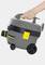 A hand is holding a grey and yellow Kärcher industrial vacuum cleaner with wheels and a carry handle.